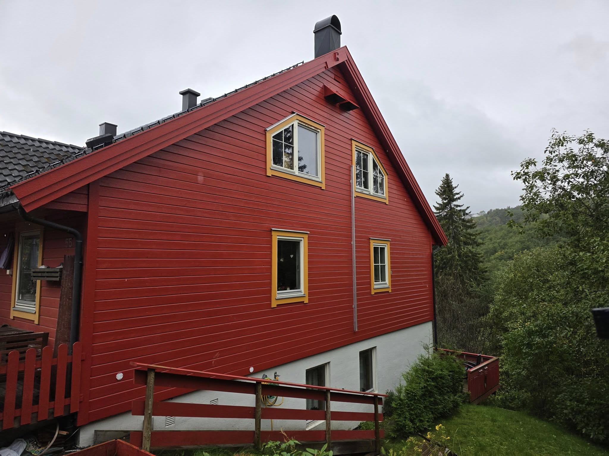 Fasade etter – nymalt hus med frisk rød farge og gule lister